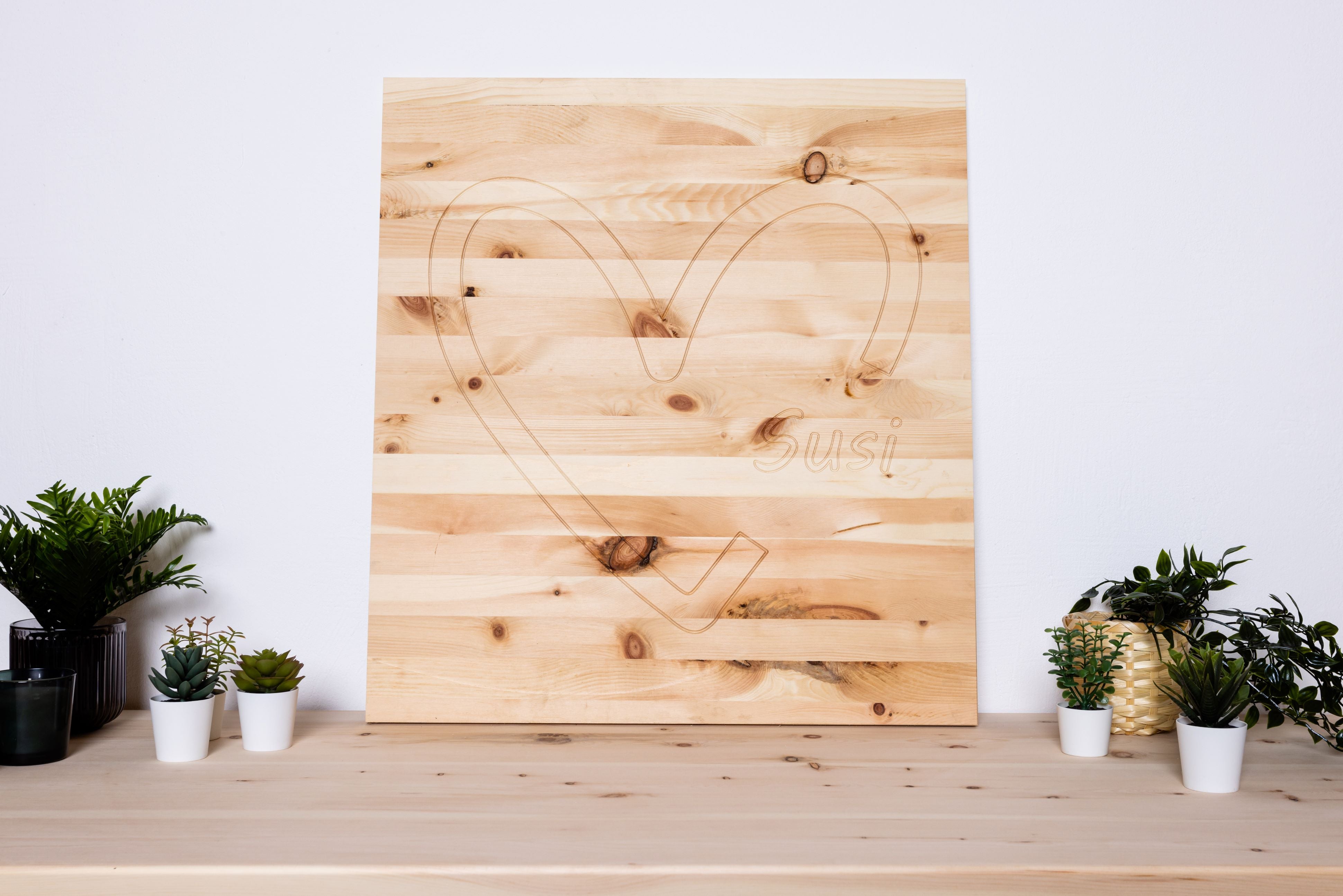 Wandbild aus Zirbenholz mit Herzmotiv auf einer Holzplatte für Wanddekoration.